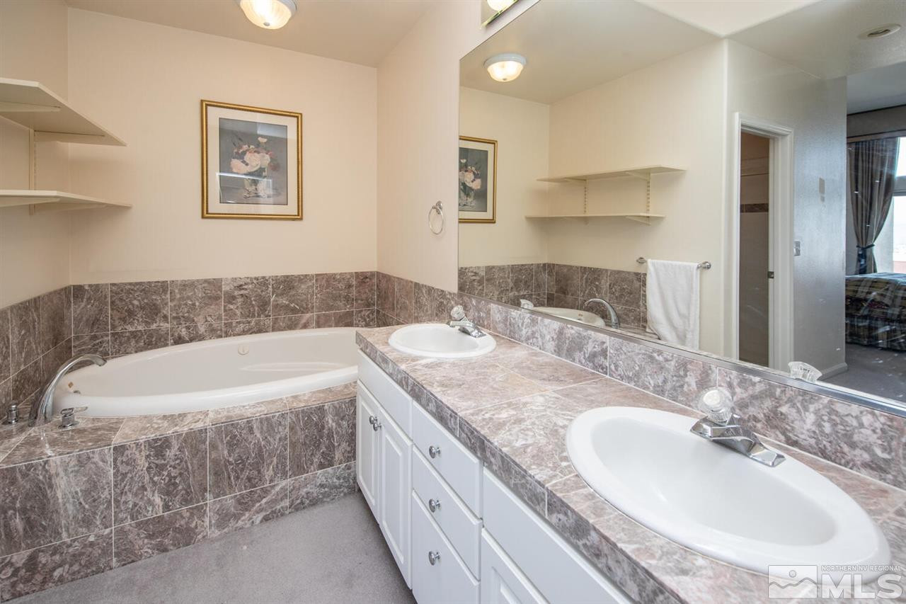 3345 Skyline Boulevard Reno, NV 89509 - Photo 15 of 38 a bathroom with a granite countertop tub a sink and mirror