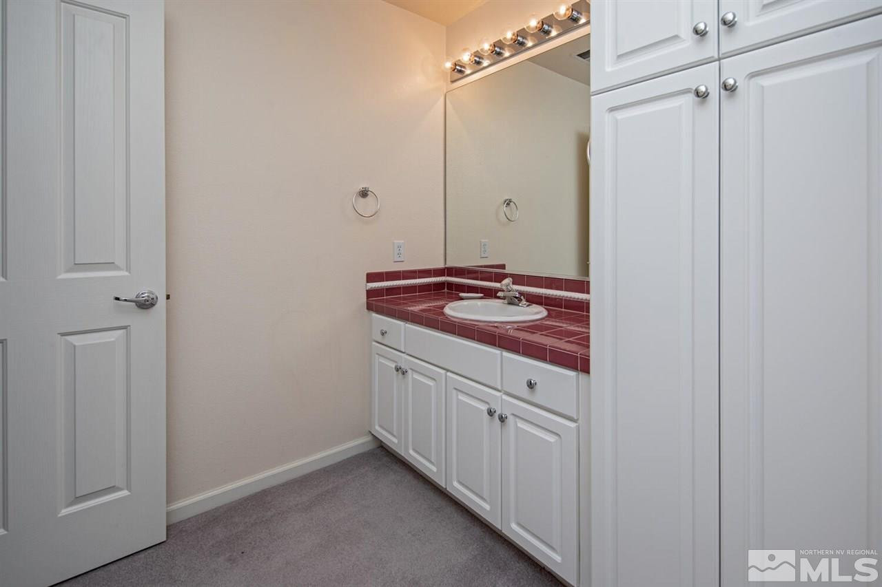 3345 Skyline Boulevard Reno, NV 89509 - Photo 27 of 38 a bathroom with a granite countertop sink and white cabinets