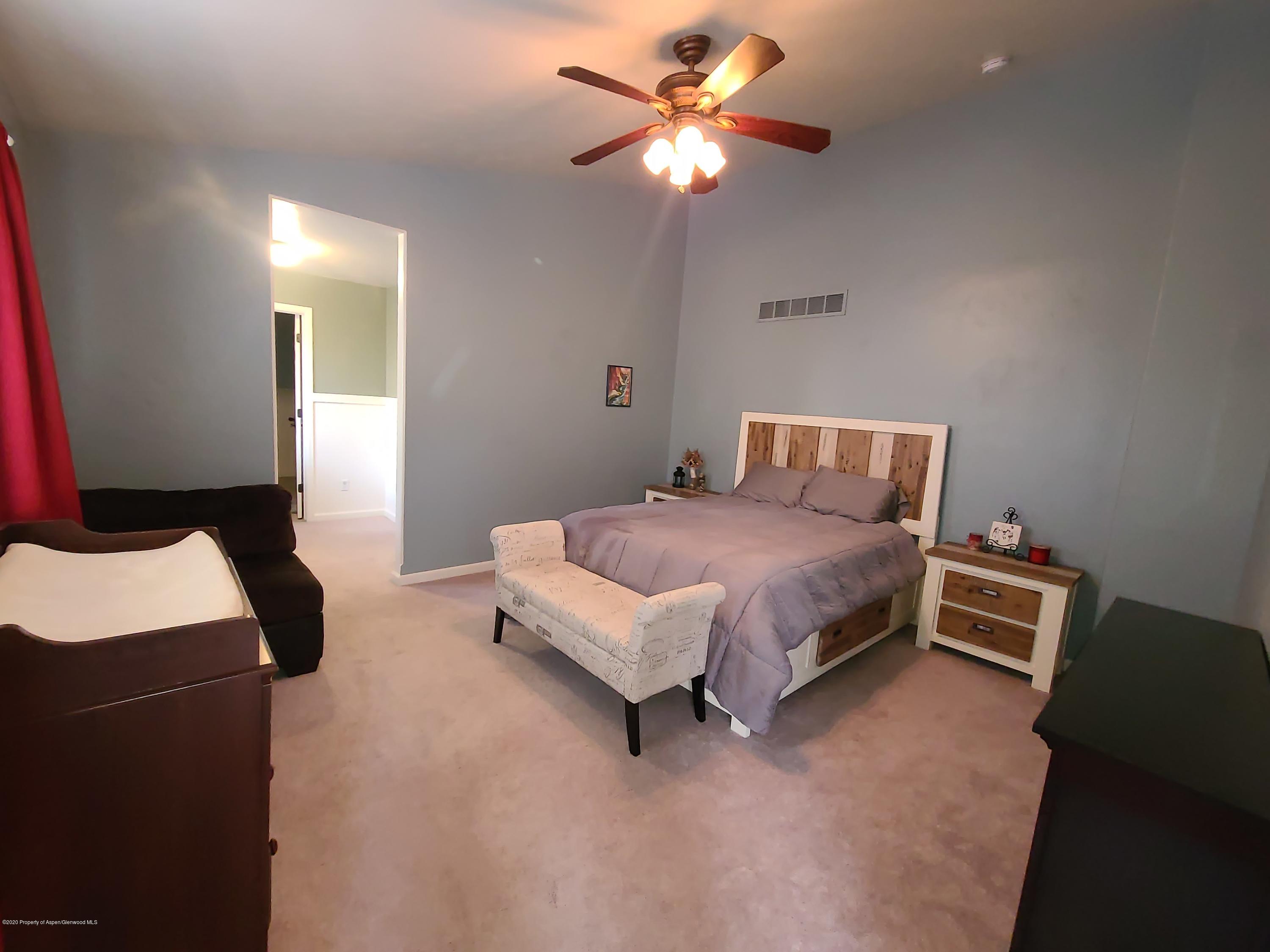 1871 Trapper Court Rifle, CO 81650 - Photo 8 of 23 a bedroom with a bed and a chandelier
