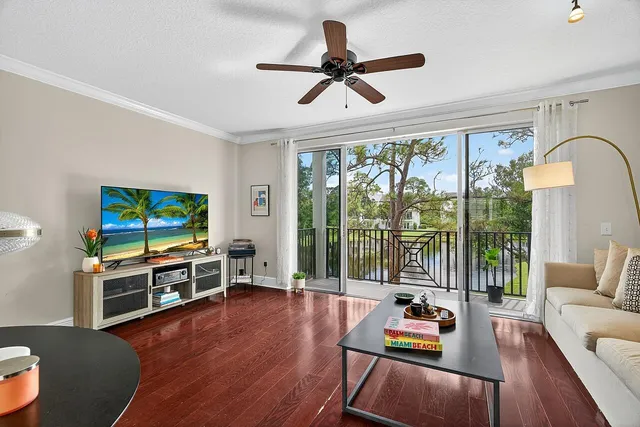 a living room with furniture a flat screen tv and a large window
