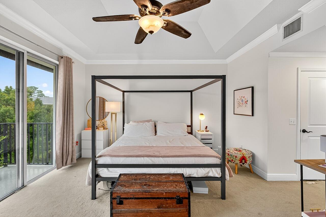 1685 42nd Square, Unit 101 Vero Beach, FL 32960 - Photo 19 of 37 a bedroom with a bed and a chandelier