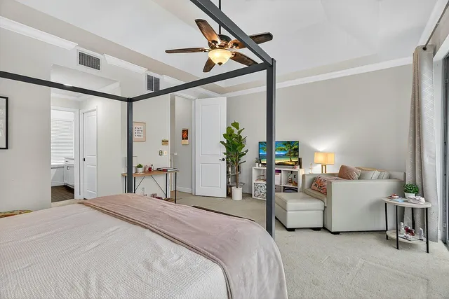 a bedroom with bed and white cabinets