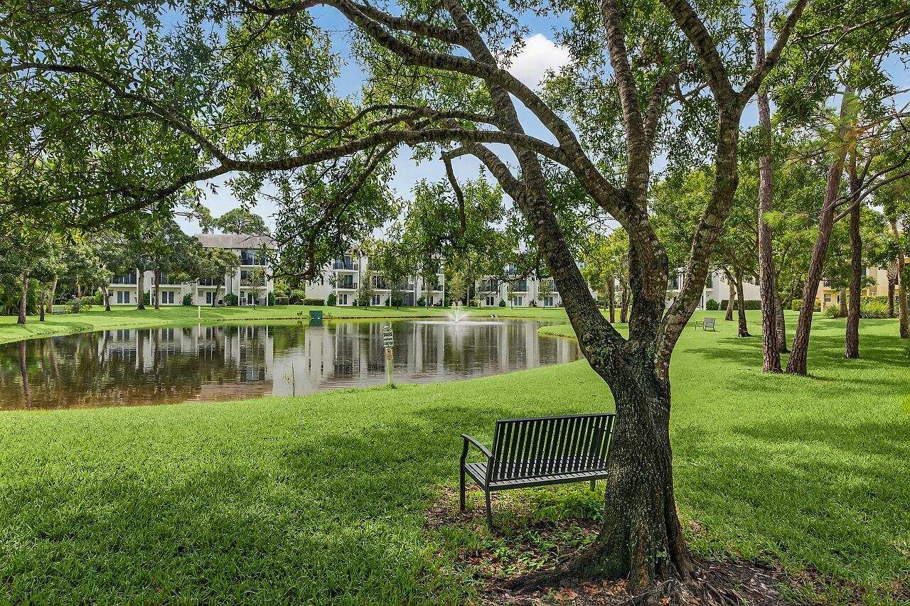 1685 42nd Square, Unit 101 Vero Beach, FL 32960 - Photo 25 of 37 a front view of a house with a yard and a large tree