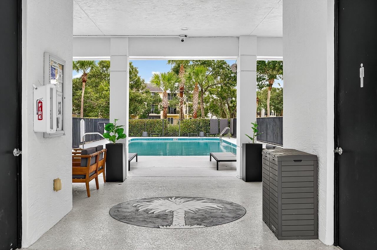 1685 42nd Square, Unit 101 Vero Beach, FL 32960 - Photo 28 of 37 a living room with furniture and a floor to ceiling window