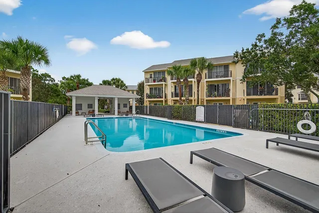 a view of a house with pool and chairs