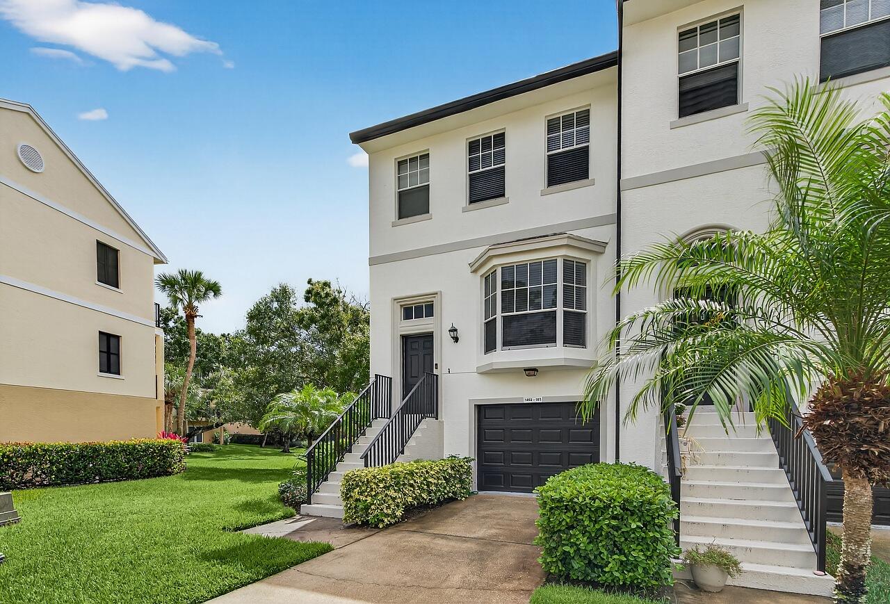 1685 42nd Square, Unit 101 Vero Beach, FL 32960 - Photo 5 of 37 a front view of a house with a yard and garage