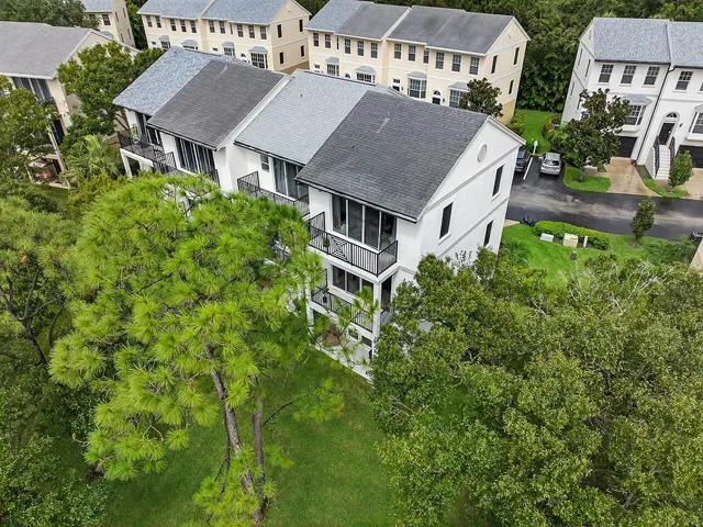 an aerial view of residential houses with yard and trees
