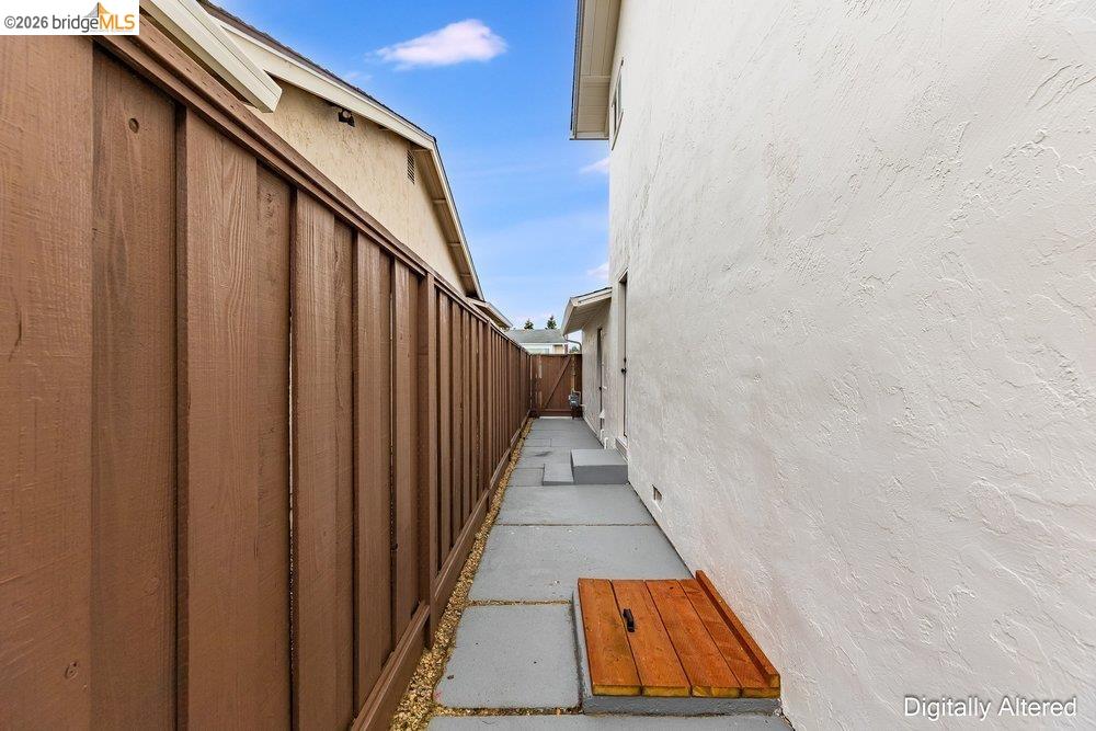 1298 Ribbon Street Foster City, CA 94404 - Photo 70 of 86 Side yard featuring a privacy fence, stucco exterior, concrete pathway, and steps to a rear door