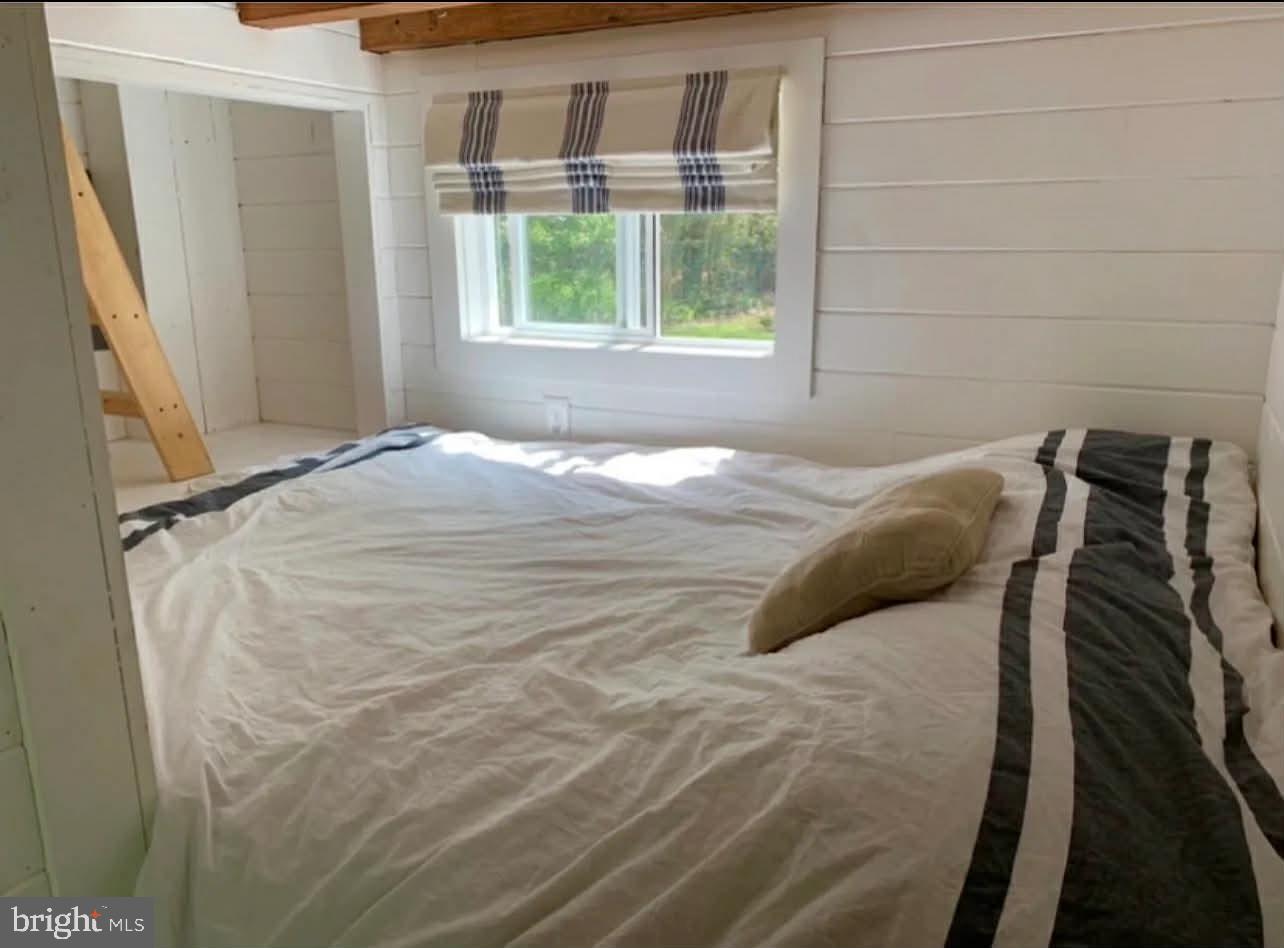 561 Corsons Tavern Road, Unit 43 Ocean View, NJ 08230 - Photo 15 of 18 a bed sitting in a bedroom next to a window