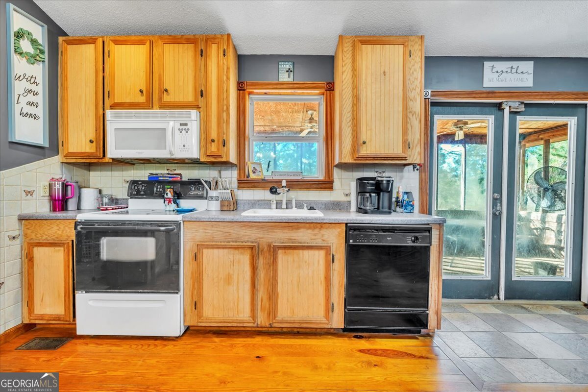 874 Mistletoe Road Abbeville, GA 31001 - Photo 22 of 67 a kitchen with a sink stove and cabinets
