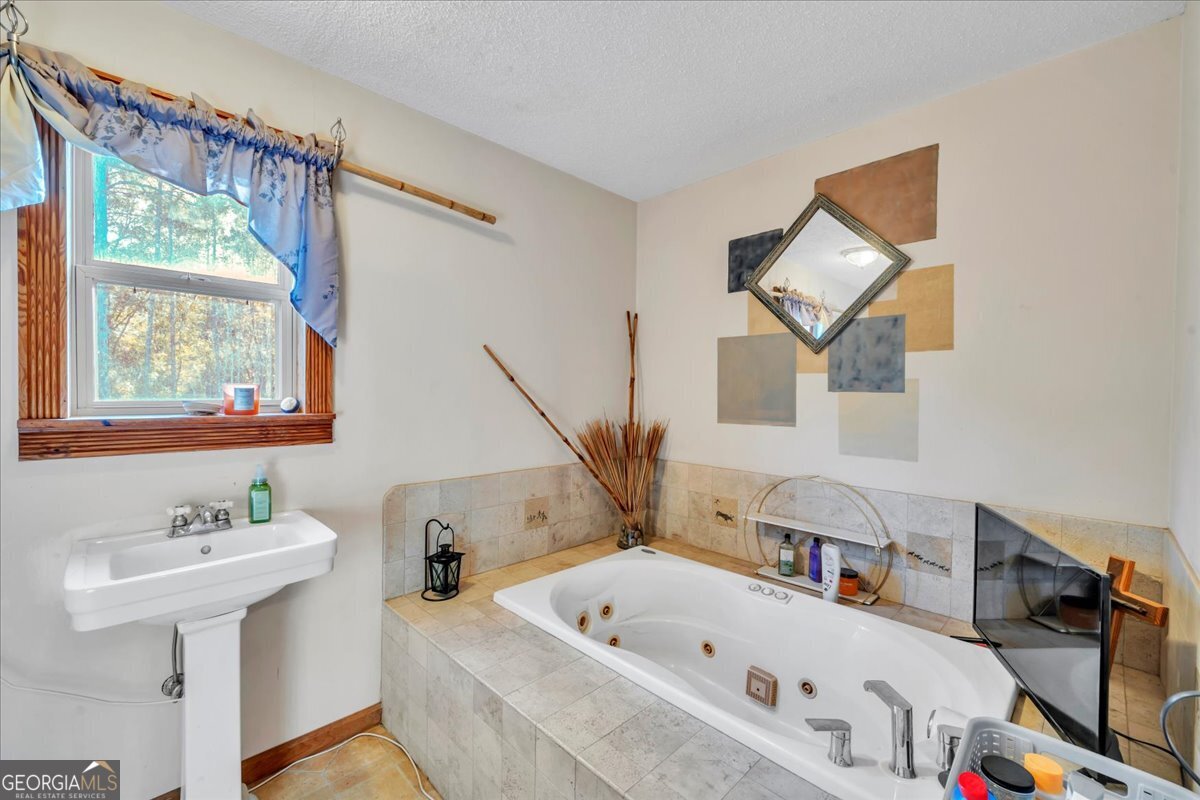 874 Mistletoe Road Abbeville, GA 31001 - Photo 33 of 67 a bathroom with a tub sink and mirror