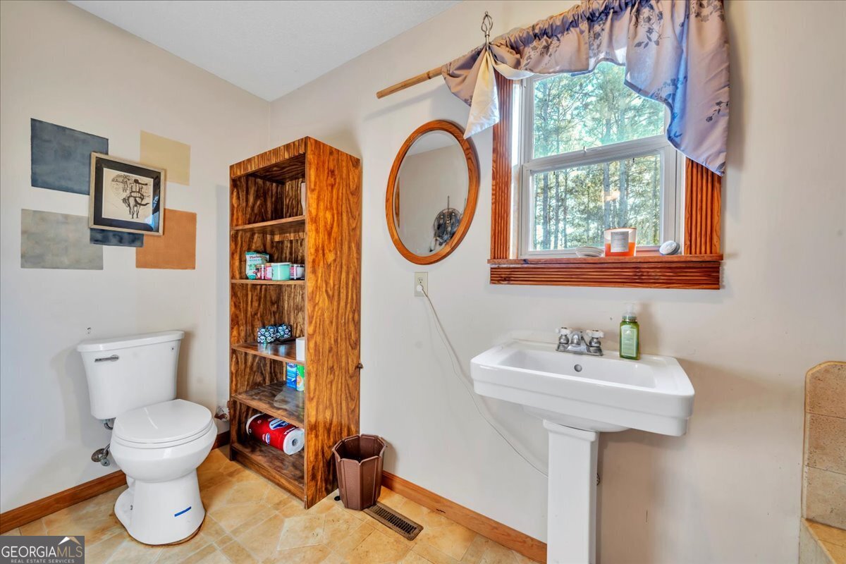 874 Mistletoe Road Abbeville, GA 31001 - Photo 34 of 67 a bathroom with a toilet sink and mirror