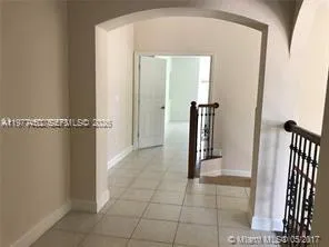 a view of a hallway with wooden floor and a bathroom