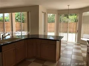 a kitchen with granite countertop a stove a sink dishwasher and a wooden cabinets