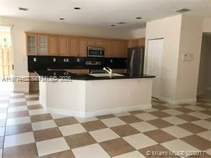 a kitchen with a checkered floor and white cabinets