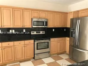 a kitchen with stainless steel appliances granite countertop a refrigerator a stove a sink and dishwasher