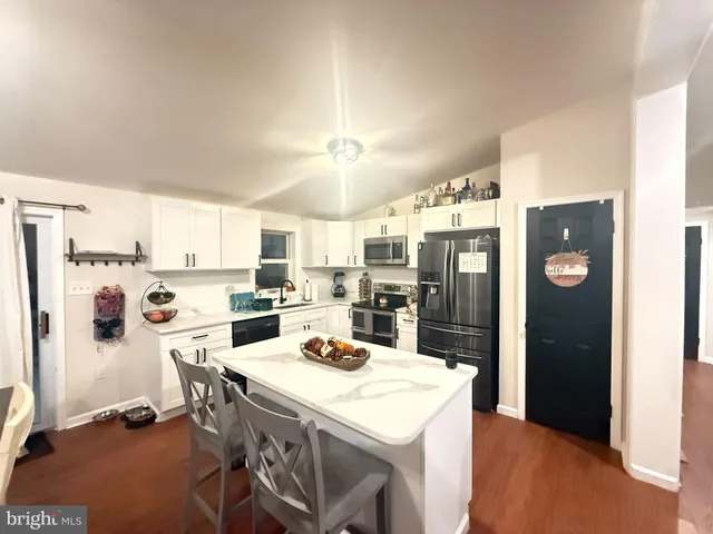 a kitchen with a refrigerator a stove a sink and a refrigerator with wooden floor