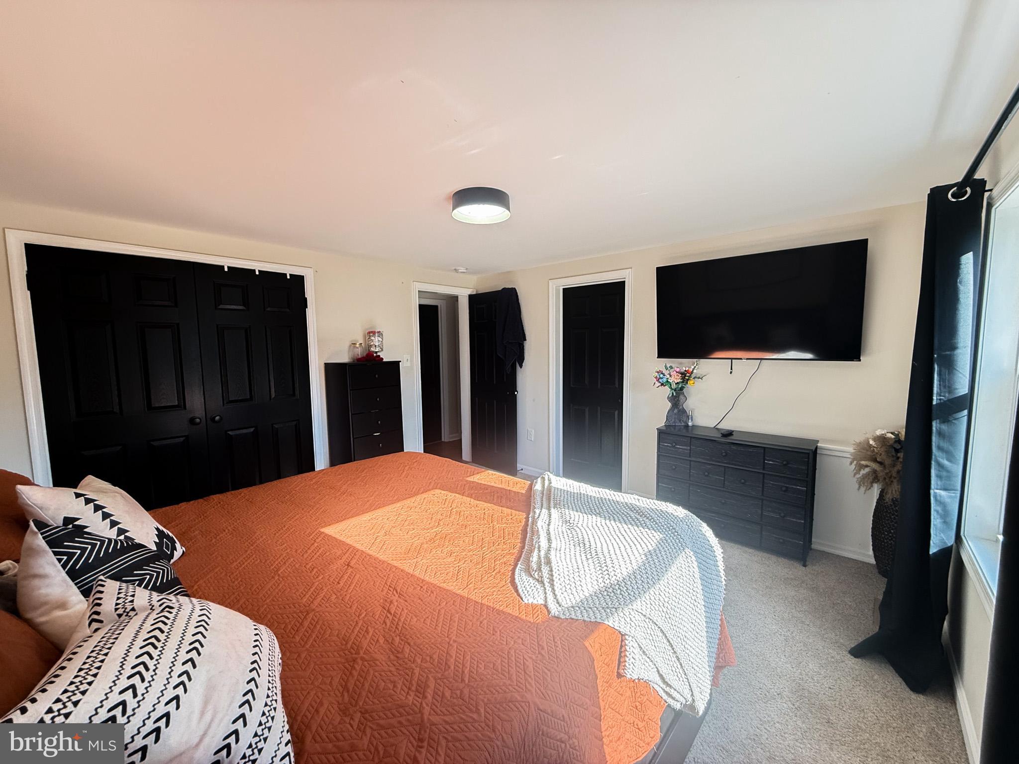 77 Martin Road Conowingo, MD 21918 - Photo 9 of 24 a bedroom with a bed and a flat tv screen on wall