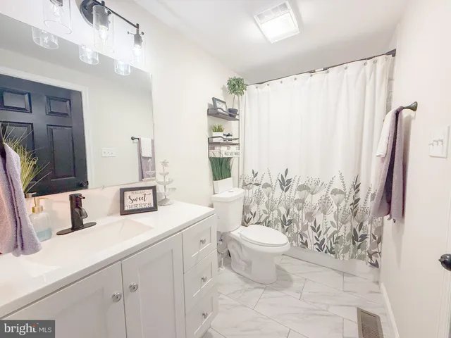 a bathroom with a granite countertop sink a toilet and a mirror