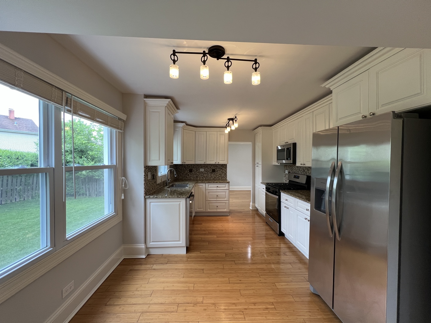 1108 Devonshire Road Buffalo Grove, IL 60089 - Photo 6 of 22 a large kitchen with kitchen island a large counter space stainless steel appliances and a large window
