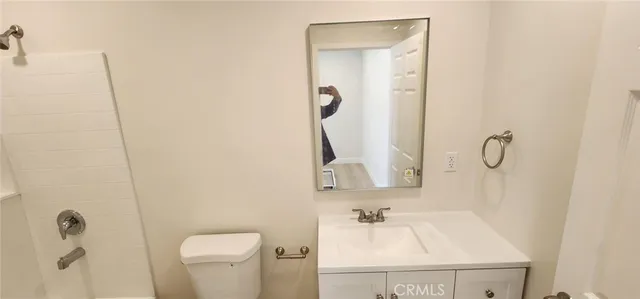 a bathroom with a sink vanity and toilet