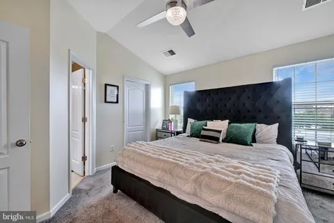 a bedroom with a large bed and a chandelier