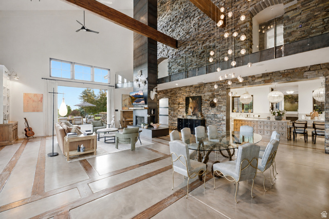 5971 Maple Ridge Trail Oakley, UT 84055 - Photo 4 of 43 Vaulted great room featuring stone accent walls, high ceilings with exposed wood beams, and a fireplace with a stone surround