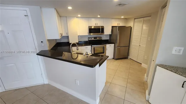 a kitchen with granite countertop a refrigerator and a sink