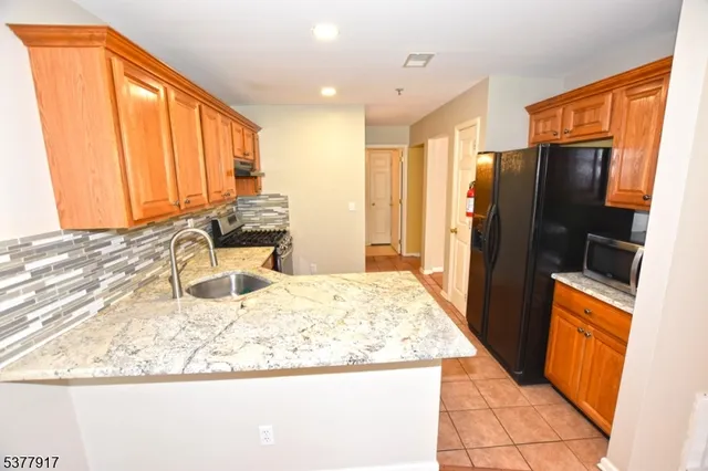 a kitchen with stainless steel appliances granite countertop a refrigerator and a sink