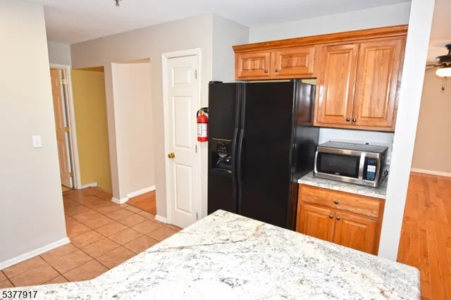 a kitchen with stainless steel appliances kitchen island granite countertop a refrigerator and a sink
