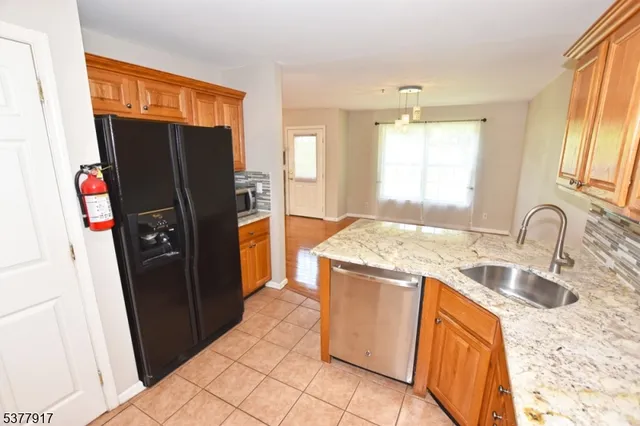 a kitchen with granite countertop a refrigerator and a sink