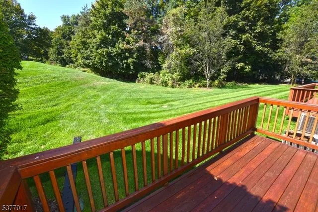 a balcony with wooden floor and trees in the back