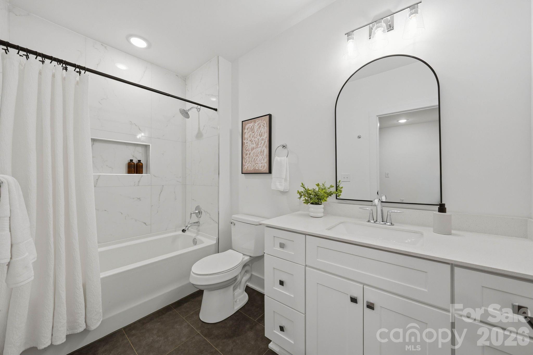 201 Grandin Road, Unit 13 Charlotte, NC 28208 - Photo 26 of 46 a bathroom with a toilet a sink a mirror a bathtub and vanity