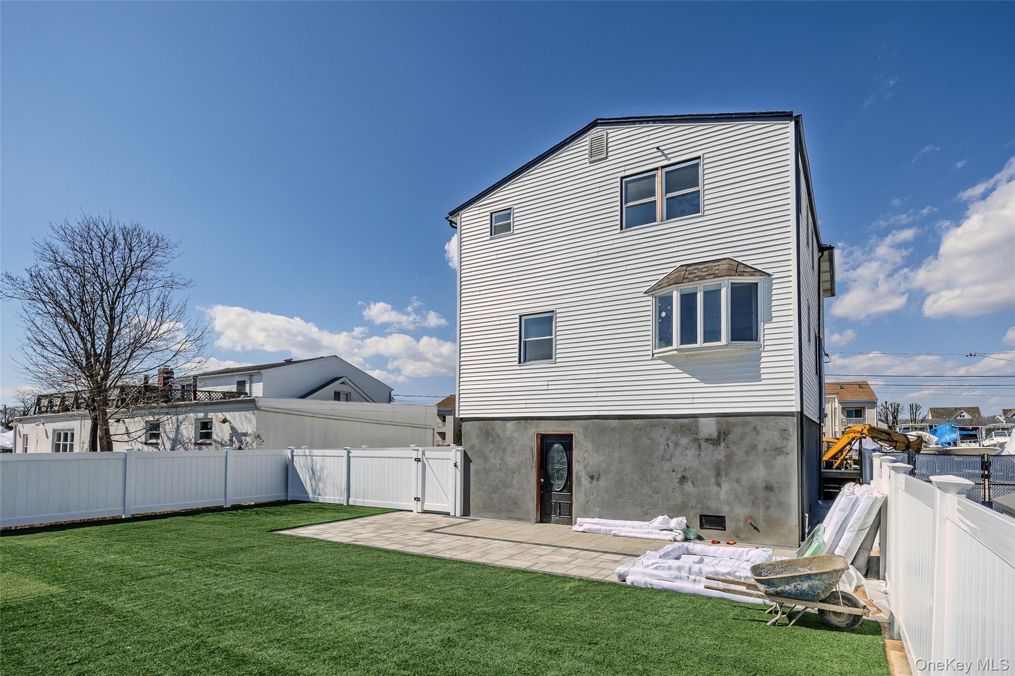 Back of property featuring a fenced backyard, a gate, a patio, and stucco siding