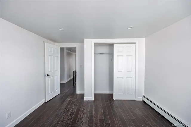 a view of hallway with stairs and wooden floor