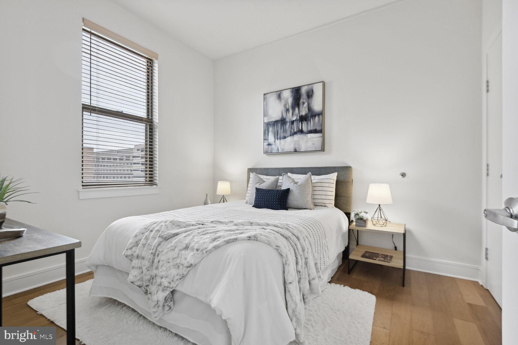 809 6th Street Northwest, Unit 65 Washington, DC 20001 - Photo 15 of 21 a bedroom with a bed a mirror and a window