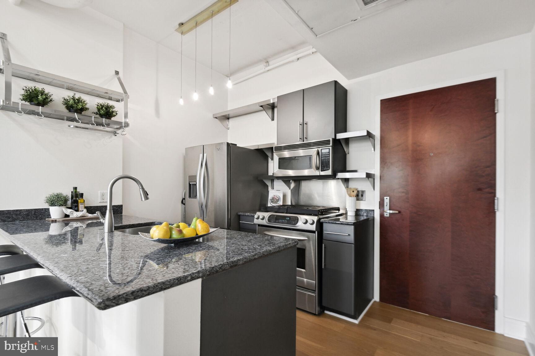809 6th Street Northwest, Unit 65 Washington, DC 20001 - Photo 7 of 21 a kitchen with stainless steel appliances granite countertop a sink a stove and a refrigerator
