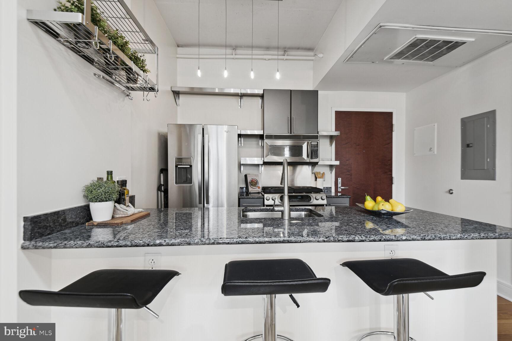 809 6th Street Northwest, Unit 65 Washington, DC 20001 - Photo 9 of 21 a kitchen with stainless steel appliances granite countertop a sink and a refrigerator