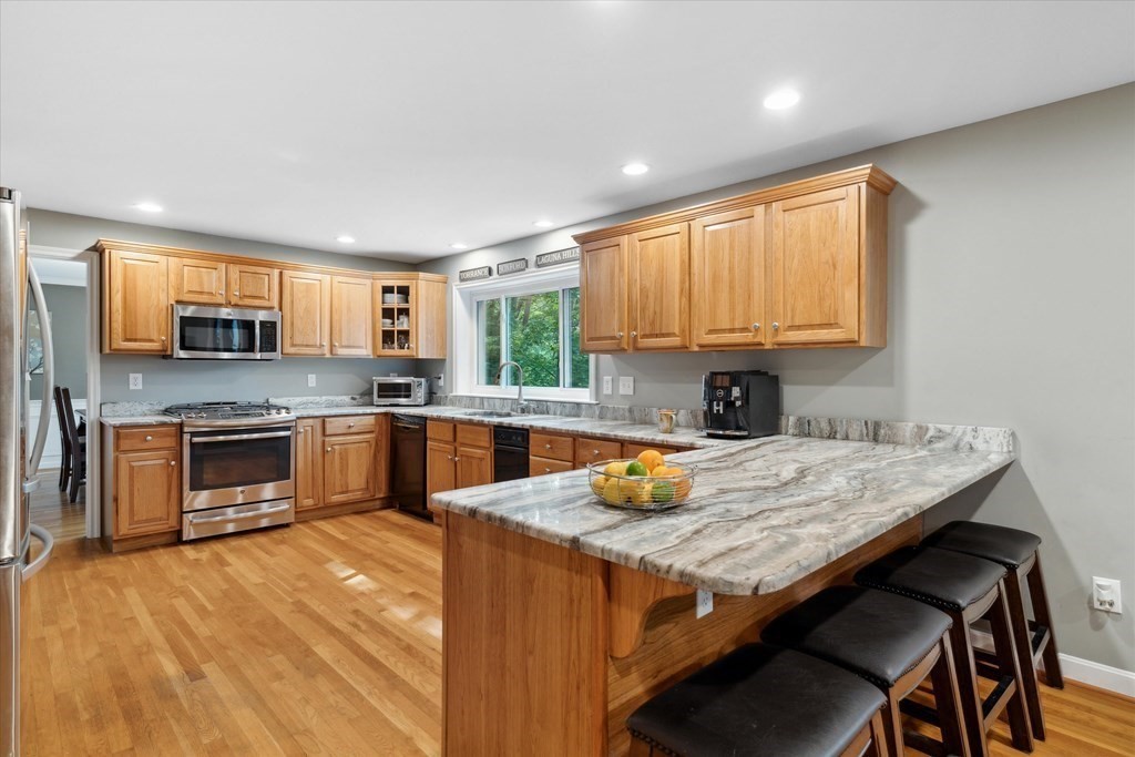 10 Fieldstone Way Boxford, MA 01921 - Photo 10 of 42 a kitchen with a stove a sink a microwave and wooden cabinets