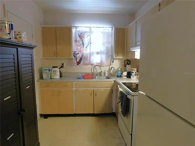 a kitchen with a stove sink and cabinets