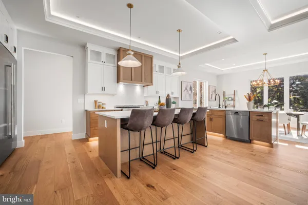 a kitchen with kitchen island a counter top space a sink stainless steel appliances and cabinets