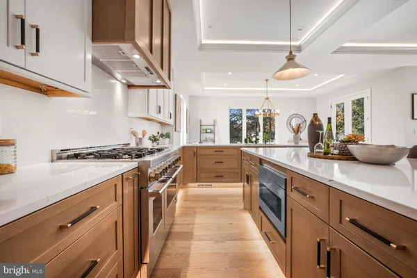 a dining room with wooden floor a chandelier a wooden table and chairs