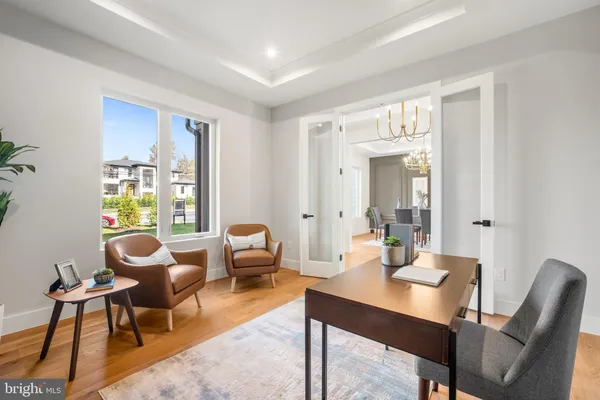a kitchen with stainless steel appliances kitchen island granite countertop a table chairs and a wooden floor