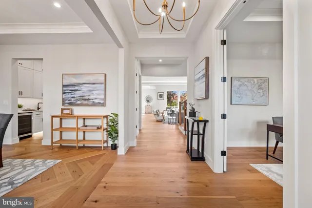 a kitchen with stainless steel appliances kitchen island granite countertop a table chairs and a wooden floor