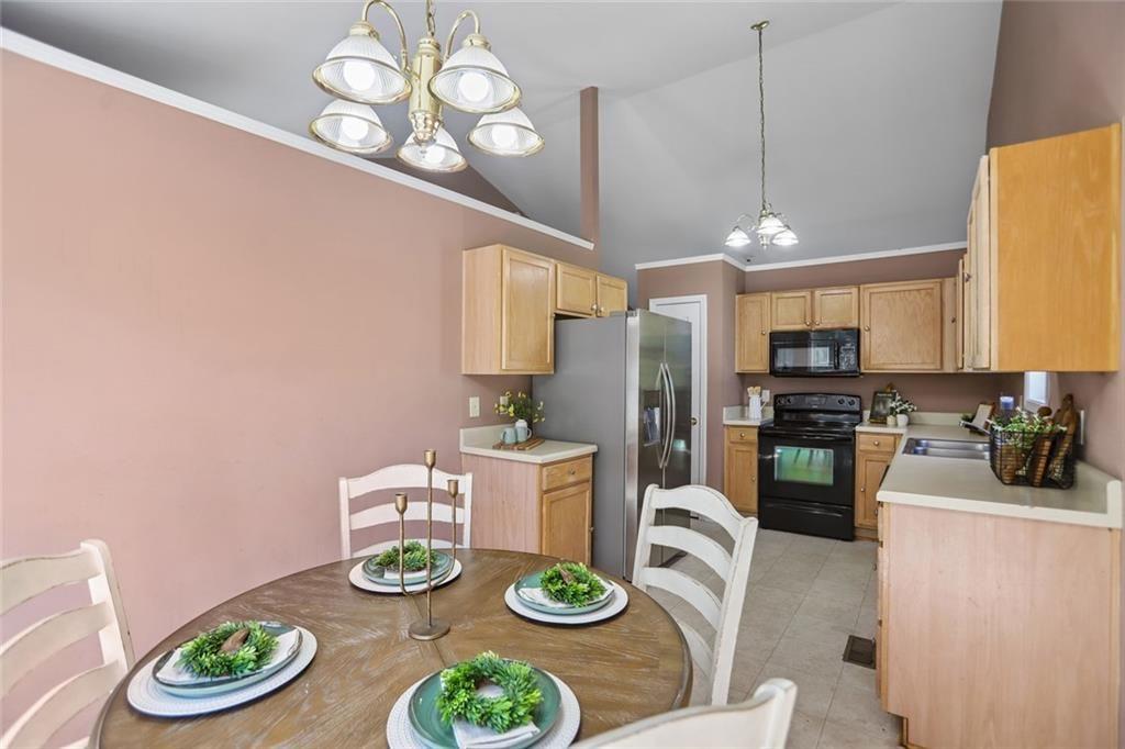 9720 Poole Road Villa Rica, GA 30180 - Photo 11 of 40 a kitchen with stainless steel appliances a dining table and chairs