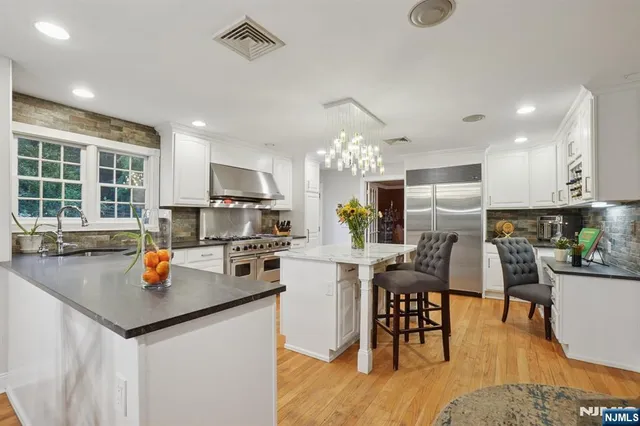 a kitchen with a table chairs refrigerator and dining table