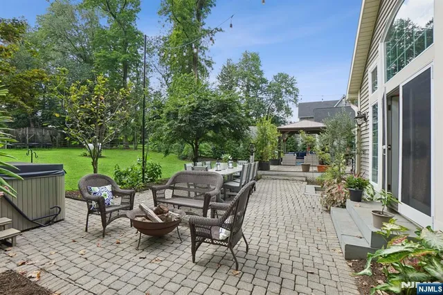 a view of a patio with table and chairs potted plants and a palm tree