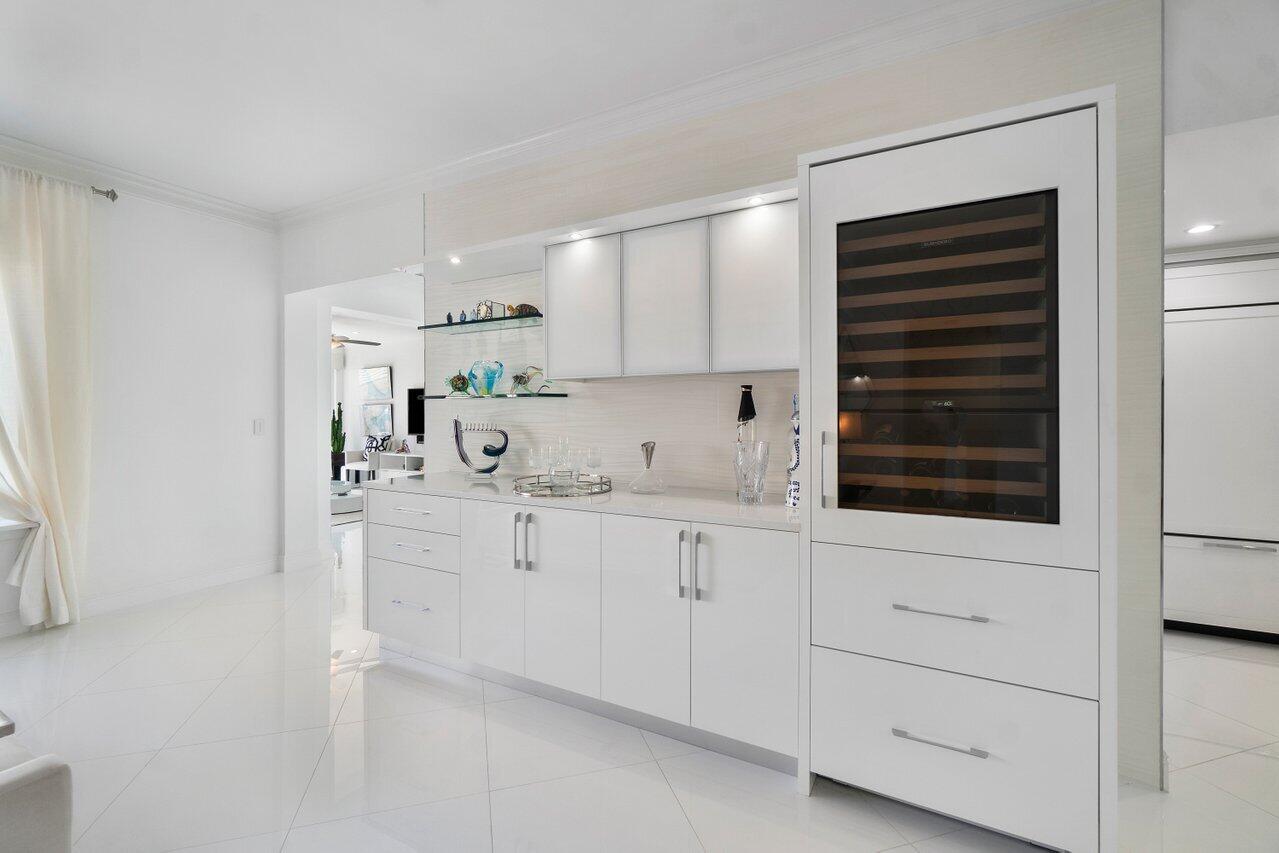 2665 North Ocean Boulevard, Unit 3 Gulf Stream, FL 33483 - Photo 22 of 50 a kitchen with granite countertop white cabinets and sink