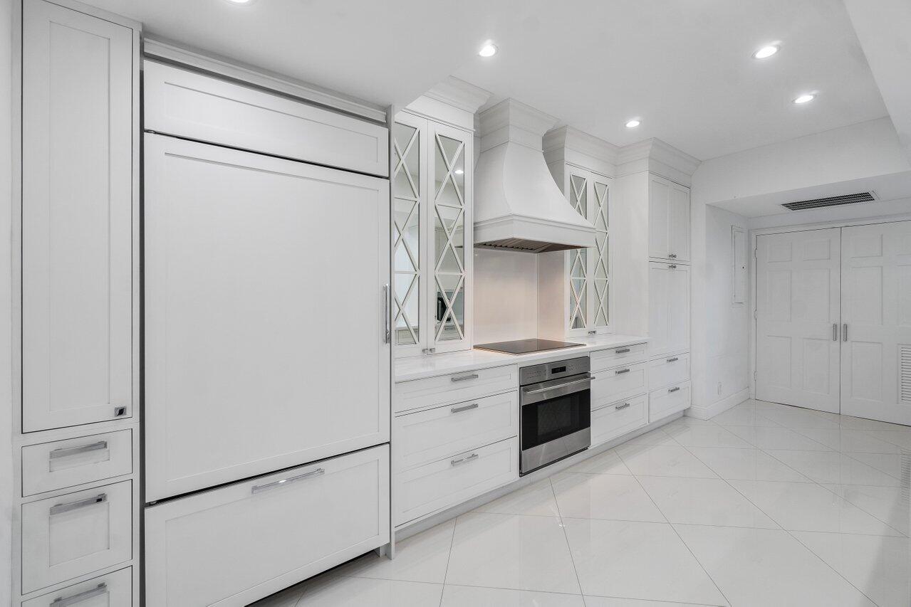 2665 North Ocean Boulevard, Unit 3 Gulf Stream, FL 33483 - Photo 24 of 50 a large white kitchen with cabinets a washer and dryer