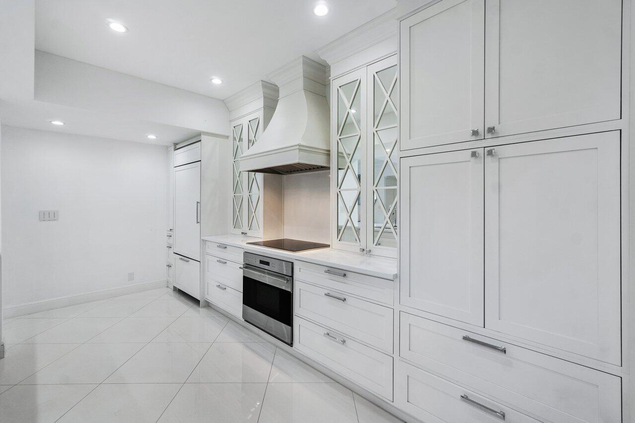2665 North Ocean Boulevard, Unit 3 Gulf Stream, FL 33483 - Photo 25 of 50 a kitchen with white cabinets and white appliances